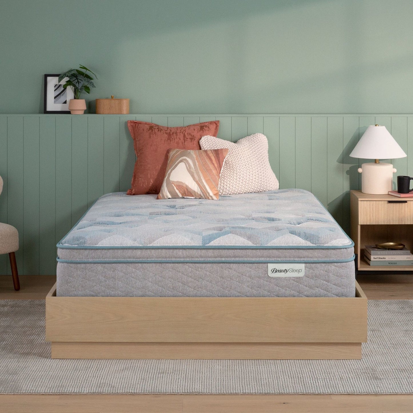 Beautysleep by Beautyrest mattress in a brown bedframe in a room setting with a lamp and nightstand.