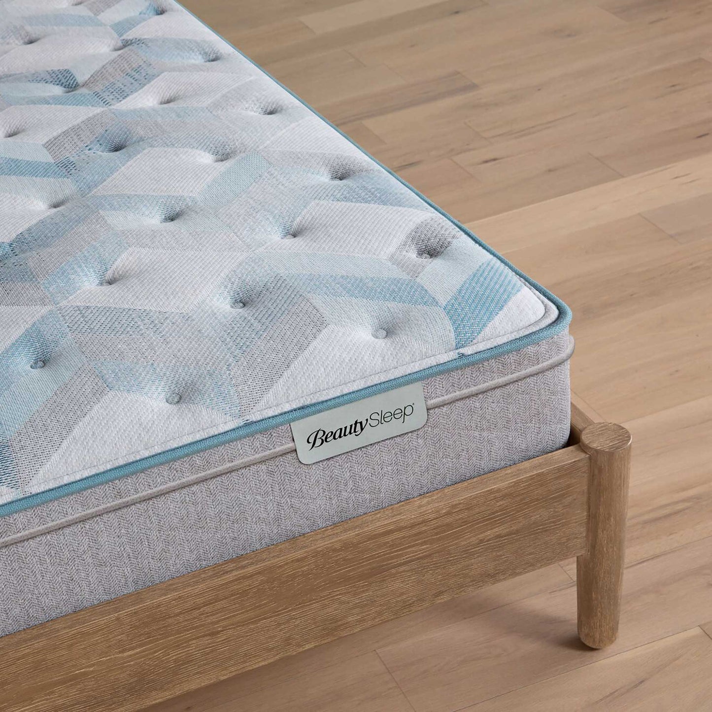 Beautysleep by Beautyrest mattress Gray quilted mattress on a wooden bed frame with 'BeautySleep' branding.