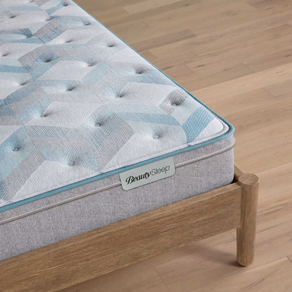 Beautysleep by Beautyrest mattress Gray quilted mattress on a wooden bed frame with 'BeautySleep' branding.