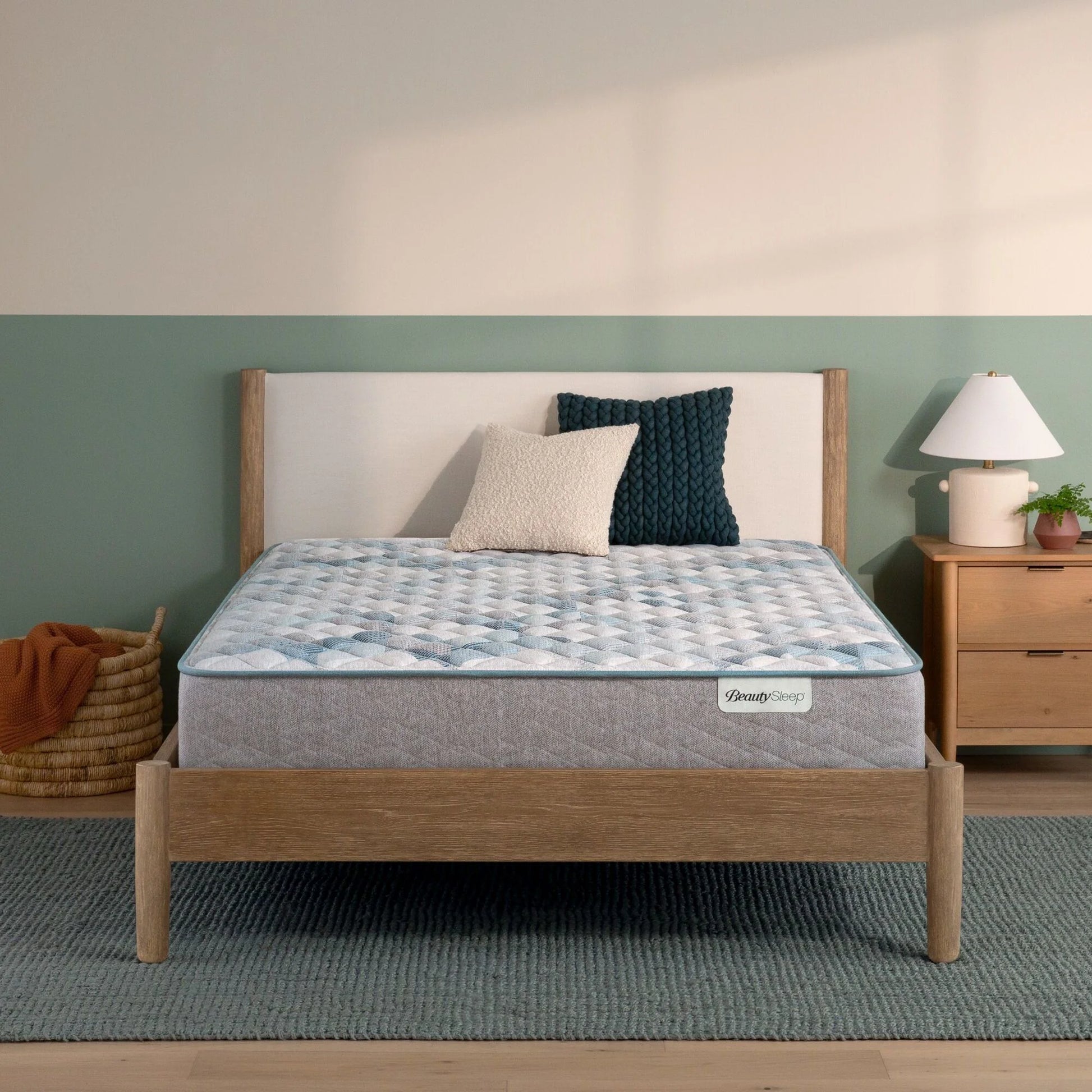 Beautysleep by Beautyrest mattress in a brown bedframe in a room setting with a lamp and nightstand.